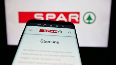 Stuttgart, Almanya - 03-07-2025: İsviçreli perakende şirketi SPAR Holding AG 'nin logosunu taşıyan cep telefonu iş sitesinin önünde ekranda. Telefon ekranının sol üst kısmına odaklan.