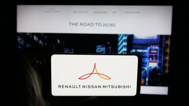 Stuttgart, Almanya - 03-07-2025: Otomotiv kuruluşu Renault-Nissan-Mitsubishi Alliance 'ın logosunun bulunduğu cep telefonu iş sayfası önünde ekranda. Telefon ekranına odaklan.