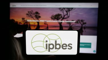 Stuttgart, Almanya - 03-07-2025: Hükümetlerarası örgüt IPBES logosu olan cep telefonu web sayfası önünde ekranda. Telefon ekranına odaklan.