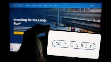 Stuttgart, Almanya - 03-07-2025: ABD 'li emlak şirketi W. P. Carey Inc.' in logosunun bulunduğu cep telefonu web sitesinin önünde ekranda. Telefon ekranına odaklan.