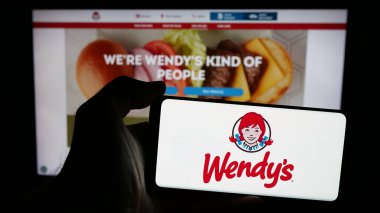 Stuttgart, Almanya - 03-07-2025: ABD 'li restoran şirketi Wendys International LLLC' nin logosunun bulunduğu cep telefonu web sayfası önünde ekranda. Telefon ekranına odaklan.