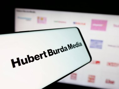 Stuttgart, Almanya - 03-07-2025: Alman Hubert Burda Media Holding KG logosuna sahip akıllı telefon, iş dünyasının web sitesi önünde ekranda. Telefon ekranının merkez soluna odaklan.