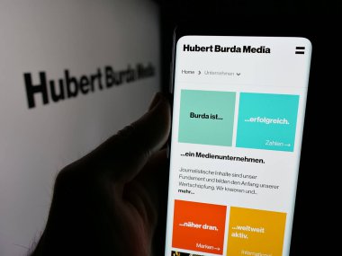 Stuttgart, Almanya - 03-07-2025: Alman Hubert Burda Media Holding KG 'nin logosunun bulunduğu web sayfası logonun önünde ekranda. Telefon ekranının merkezine odaklan.