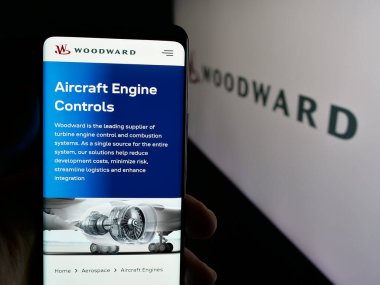 Stuttgart, Almanya - 03-09-2025: ABD 'li kontrol sistemleri şirketi Woodward Inc.' in web sayfası olan cep telefonu logonun önünde ekranda. Telefon ekranının merkezine odaklan.