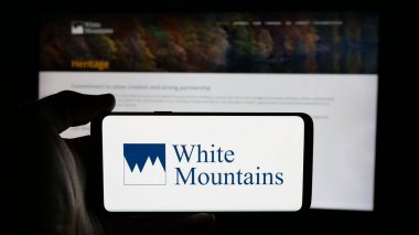 Stuttgart, Almanya - 03-09-2025: Web sayfasının önünde White Mountains Sigorta Grubu Ltd. şirketinin logosunun bulunduğu cep telefonu sahibi kişi. Telefon ekranına odaklan.