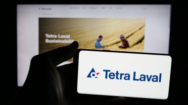 Stuttgart, Almanya - 03-10-2025: İnternet sayfasının önünde ambalaj şirketi Tetra Laval Group 'un logosunun bulunduğu cep telefonu sahibi kişi. Telefon ekranına odaklan.