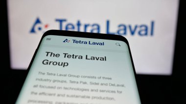 Stuttgart, Almanya - 03-10-2025: Sitenin önünde ekranda ambalaj şirketi Tetra Laval Group 'un logosunun bulunduğu cep telefonu. Telefon ekranının sol üst kısmına odaklan.