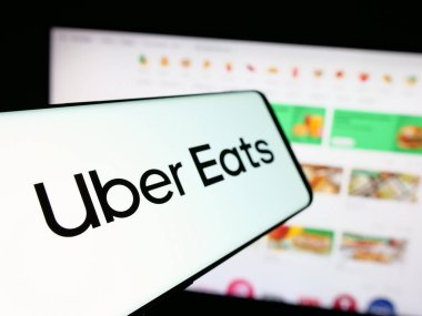 Stuttgart, Almanya - 03-12-2025: İnternet sitesi önünde ekranda Uber Eats adlı ABD 'li çevrimiçi gıda dağıtım şirketinin logosuna sahip akıllı telefon. Telefon ekranının merkez soluna odaklan.