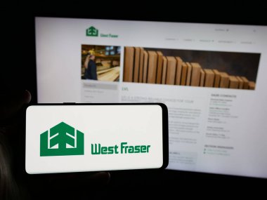 Stuttgart, Almanya - 03-12-2025: Orman şirketi West Fraser Timber Co. Ltd. nin logosuna sahip akıllı telefon sahibi kişi web sitesinin önünde ekranda. Telefon ekranına odaklan.