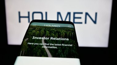 Stuttgart, Almanya - 03-12-2025: İnternet sitesi önünde ekranda İsveçli ormancılık şirketi Holmen AB 'nin logosuna sahip cep telefonu. Telefon ekranının sol üst kısmına odaklan.