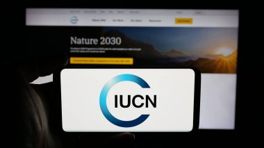 Stuttgart, Almanya - 03-12-2025: Uluslararası çevre örgütü IUCN 'nin logosunun bulunduğu cep telefonu web sayfası önünde ekranda. Telefon ekranına odaklan.