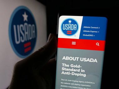 Stuttgart, Almanya - 03-12-2025: Logo önünde ABD Anti-Doping Ajansı (USADA) logosu bulunan kişi web sitesi. Telefon ekranının merkezine odaklan.