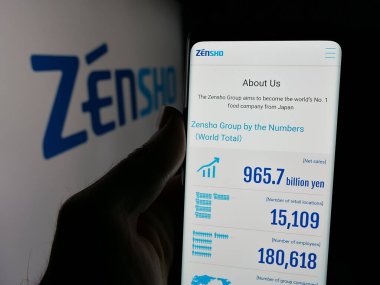 Stuttgart, Almanya - 03-13-2025: Japon restoran şirketi Zensho Co. Ltd. nin internet sayfası ile cep telefonu tutan kişi logonun önünde ekranda. Telefon ekranının merkezine odaklan.