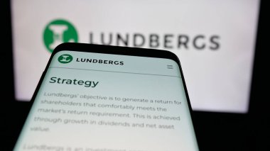 Stuttgart, Almanya - 03-14-2025: Web sitesi önünde üzerinde L E Lundbergforetagen AB (Lundbergs) şirketinin logosu bulunan cep telefonu. Telefon ekranının sol üst kısmına odaklan.