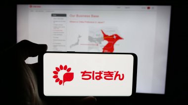Stuttgart, Almanya - 03-14-2025: Japon finans şirketi Chiba Bank Ltd. 'nin logosuyla cep telefonu sahibi kişi web sayfasının önünde ekranda. Telefon ekranına odaklan.