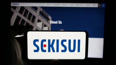Stuttgart, Almanya - 03-18-2025: Japon firması Sekisui Chemical Co. Ltd. nin logosuyla cep telefonu sahibi kişi web sayfasının önünde ekranda. Telefon ekranına odaklan.