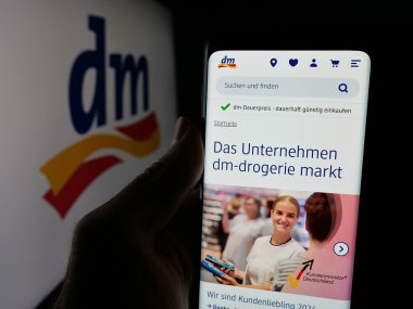 Stuttgart, Almanya - 03-19-2025: Alman şirketi dm-drogerie markt GmbH Co. KG 'nin web sayfası olan cep telefonu logonun önünde ekranda. Telefon ekranının merkezine odaklan.