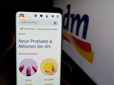 Stuttgart, Almanya - 03-19-2025: Üzerinde Alman firması dm-drogerie markt GmbH Co. KG 'nin logosu bulunan web sayfası ekranda. Telefon ekranının merkezine odaklan.