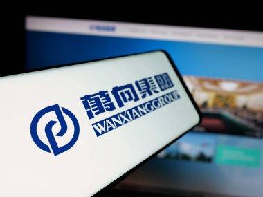 Stuttgart, Almanya - 03-19-2025: Çinli Wanxiang Group Corporation şirketinin logosunu içeren akıllı telefon web sitesinin önünde ekranda. Telefon ekranının merkez soluna odaklan.