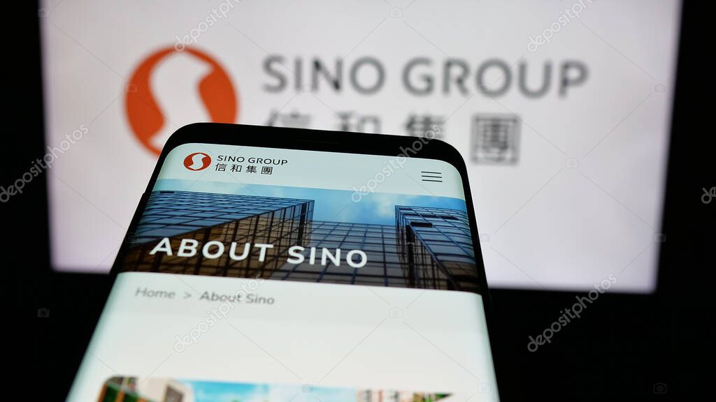 Stuttgart, Germany - 03-14-2025: Mobile phone with logo of Hong Kong real estate company Sino Group on screen in front of website. Focus on top-left of phone display.