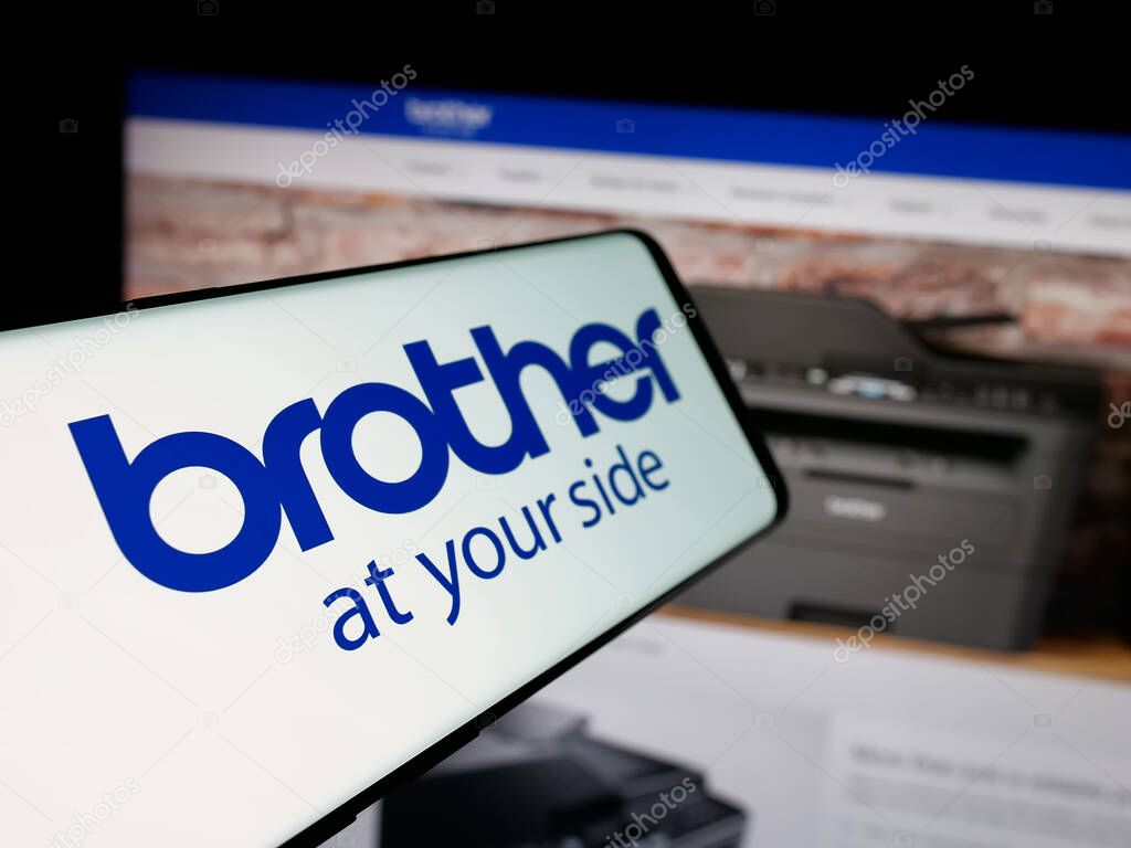 Stuttgart, Germany - 03-14-2025: Smartphone with logo of electronics company Brother Industries Ltd. on screen in front of website. Focus on center-left of phone display.