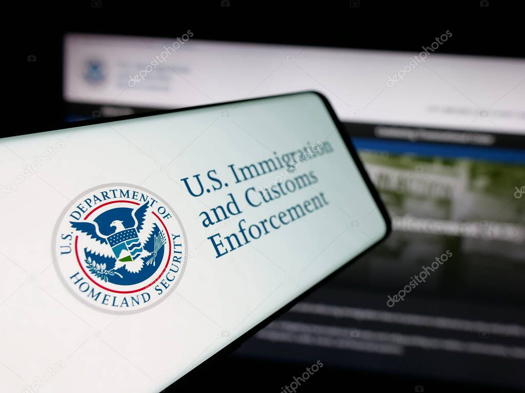 Stuttgart, Germany - 03-18-2025: Smartphone with logo of US Immigration and Customs Enforcement (ICE) on screen in front of website. Focus on center-left of phone display.