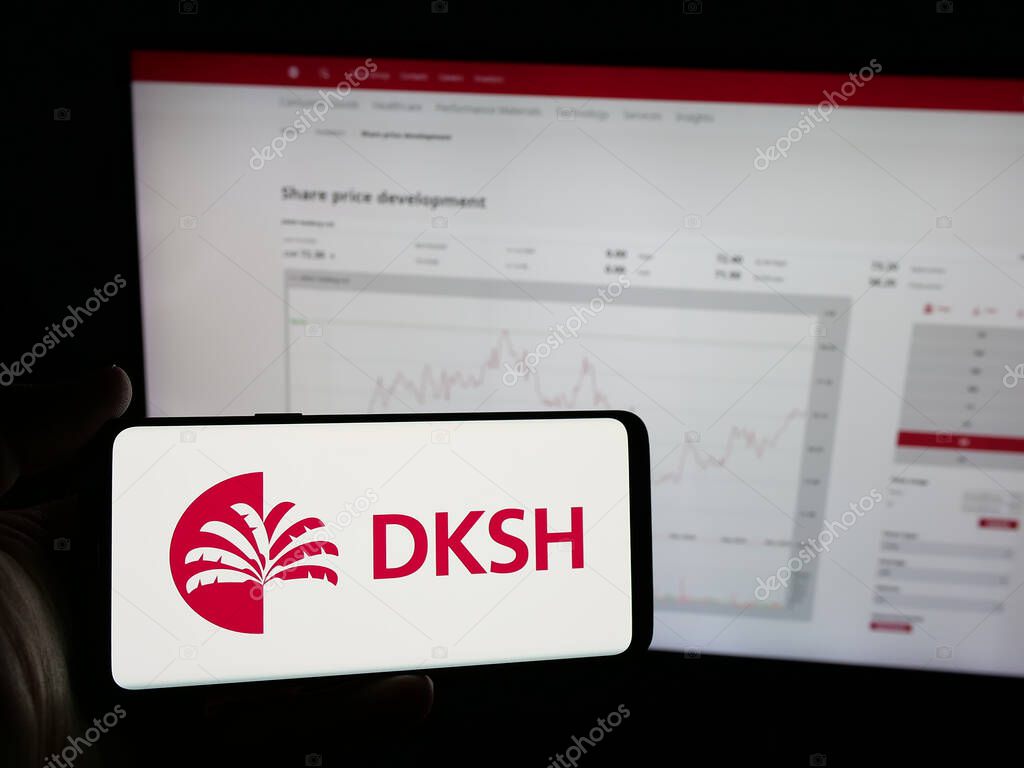 Stuttgart, Germany - 03-19-2025: Person holding smartphone with logo of Swiss outsourcing company DKSH Holding AG on screen in front of website. Focus on phone display.