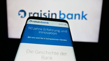 Stuttgart, Almanya - 03-20-2025: Alman finans şirketi Raisin Bank AG 'nin logolu cep telefonu web sitesinin önünde ekranda. Telefon ekranının sol üst kısmına odaklan.