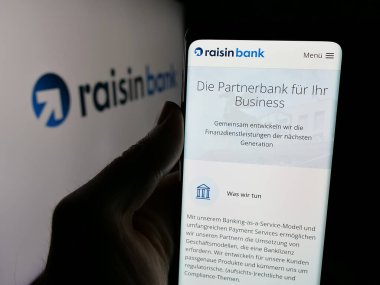 Stuttgart, Almanya - 03-20-2025: Alman finans şirketi Raisin Bank AG 'nin internet sayfası olan cep telefonu logosu önünde ekranda. Telefon ekranının merkezine odaklan.