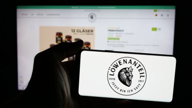 Stuttgart, Almanya - 03-20-2025: Alman organik gıda şirketi Loewenanteil GmbH 'nin logosunun bulunduğu cep telefonu web sayfası önünde ekranda. Telefon ekranına odaklan.