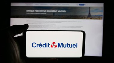Stuttgart, Almanya - 03-21-2025: Fransız bankası Caisse Federale de Credit Mutuel 'in logosunun bulunduğu cep telefonu web sayfası önünde ekranda. Telefon ekranına odaklan.