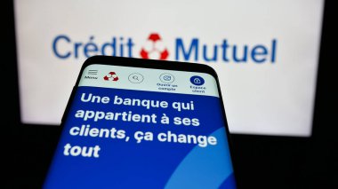 Stuttgart, Almanya - 03-21-2025: İnternet sitesinin önünde ekranda Fransız bankası Caisse Federale de Credit Mutuel 'in logosunun olduğu cep telefonu. Telefon ekranının sol üst kısmına odaklan.