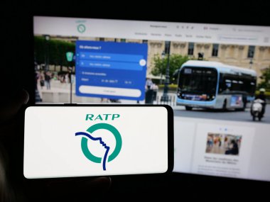Stuttgart, Almanya - 03-21-2025: İnternet sitesinin önünde üzerinde Fransız toplu taşıma şirketi RATP logosu bulunan kişi. Telefon ekranına odaklan.