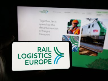 Stuttgart, Almanya - 03-21-2025: İnternet sitesi önünde, üzerinde Fransız Rail Lojistik Avrupa (RLE) logosu bulunan akıllı telefon sahibi kişi. Telefon ekranına odaklan.