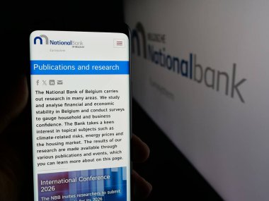 Stuttgart, Almanya - 03-21-2025: Logonun önünde Belçika Ulusal Bankası van Belgie 'nin (NBB) web sayfası bulunan kişi. Telefon ekranının merkezine odaklan.