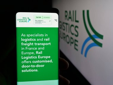 Stuttgart, Almanya - 03-21-2025: Fransız Demiryolu Lojistik Avrupa (RLE) şirketinin web sayfası logonun önünde cep telefonu tutan kişi. Telefon ekranının merkezine odaklan.