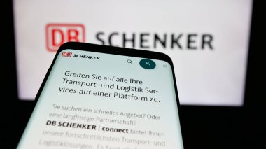 Stuttgart, Almanya - 03-21-2025: Alman lojistik şirketi DB Schenker 'in logosu olan cep telefonu web sitesinin önünde ekranda. Telefon ekranının sol üst kısmına odaklan.