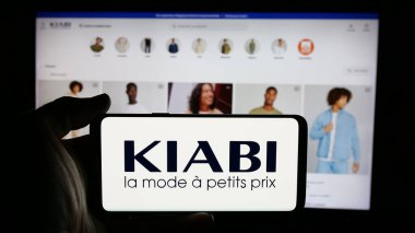 Stuttgart, Almanya - 03-21-2025: Fransız moda perakende şirketi Kiabi 'nin logosunun bulunduğu cep telefonu web sayfası önünde ekranda. Telefon ekranına odaklan.