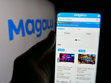 Stuttgart, Almanya - 03-24-2025: Logonun önünde perakende şirketi Luiza S.A. 'nın (Magalu) logosunun logosunun bulunduğu web sayfası bulunan kişi. Telefon ekranının merkezine odaklan.