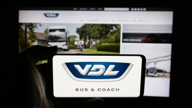 Stuttgart, Almanya - 03-24-2025: Hollandalı otomotiv şirketi VDL Otobüs ve Koç 'un logosunun bulunduğu cep telefonu web sayfası önünde ekranda. Telefon ekranına odaklan.