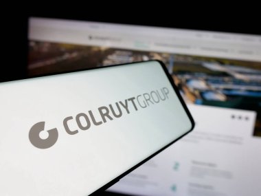Stuttgart, Almanya - 03-24-2025: Belçikalı perakende şirketi Colruyt Group N.V. 'nin logosuna sahip akıllı telefon web sitesinin önünde ekranda. Telefon ekranının merkez soluna odaklan.