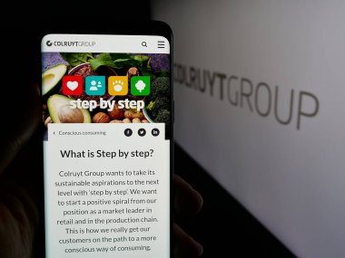 Stuttgart, Almanya - 03-24-2025: Belçikalı perakende şirketi Colruyt Group NV 'nin logosunun bulunduğu web sayfası logonun önünde ekranda. Telefon ekranının merkezine odaklan.
