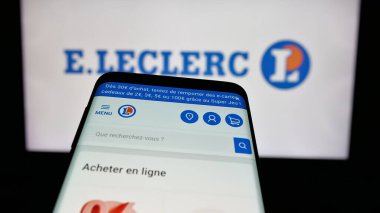 Stuttgart, Almanya - 03-24-2025: İnternet sitesi önünde ekranda Fransız perakende şirketi E.Leclerc 'in logosuna sahip cep telefonu. Telefon ekranının sol üst kısmına odaklan.