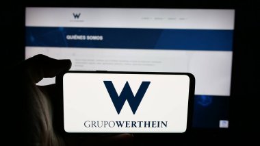 Stuttgart, Almanya - 03-24-2025: Arjantinli şirket Grupo Werthein 'in logosunun bulunduğu cep telefonu web sayfası önünde ekranda. Telefon ekranına odaklan.