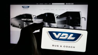 Stuttgart, Almanya - 03-24-2025: Hollandalı otomotiv şirketi VDL Otobüs ve Koç 'un logosunun bulunduğu cep telefonu web sayfasının önünde duruyor. Telefon ekranına odaklan.