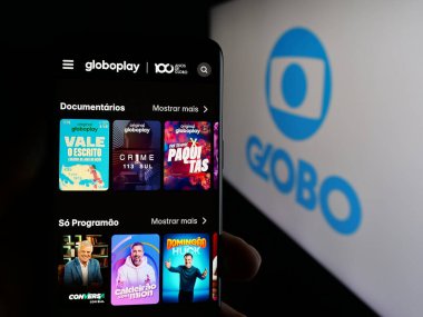 Stuttgart, Almanya - 03-27-2025: Brezilyalı televizyon kanalı Globo 'nun web sayfası olan cep telefonu logonun önünde ekranda. Telefon ekranının merkezine odaklan.