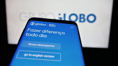 Stuttgart, Almanya - 03-27-2025: Brezilyalı medya ve televizyon şirketi Grupo Globo 'nun logosuna sahip cep telefonu web sitesinin önünde ekranda. Telefon ekranının sol üst kısmına odaklan.