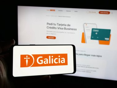 Stuttgart, Almanya - 03-27-2025: Elinde bankacılık şirketi Grupo Financiero Galicia S.A. 'nın logosunun bulunduğu akıllı telefon bulunan kişi web sitesinin önünde ekranda. Telefon ekranına odaklan.