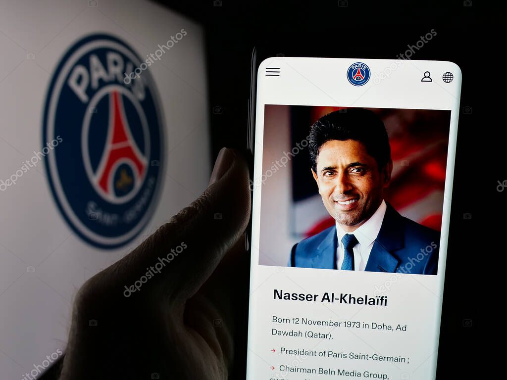 Stuttgart, Germany - 03-21-2025: Person holding web page with logo of Paris Saint-Germain Football Club (PSG) on screen in front of logo. Focus on center of phone display.
