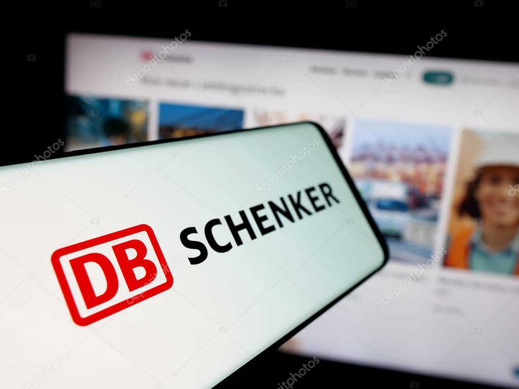 Stuttgart, Germany - 03-21-2025: Smartphone with logo of German logistics company DB Schenker on screen in front of website. Focus on center-left of phone display.